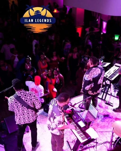 The band and crowd under pink and purple lights