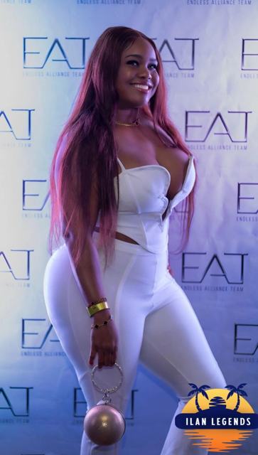 A guest in white posing at the photo booth