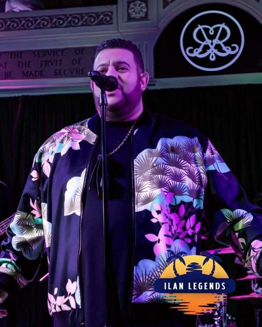 A vocalist on stage in a floral jacket