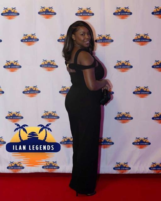 A guest in a black dress on the red carpet