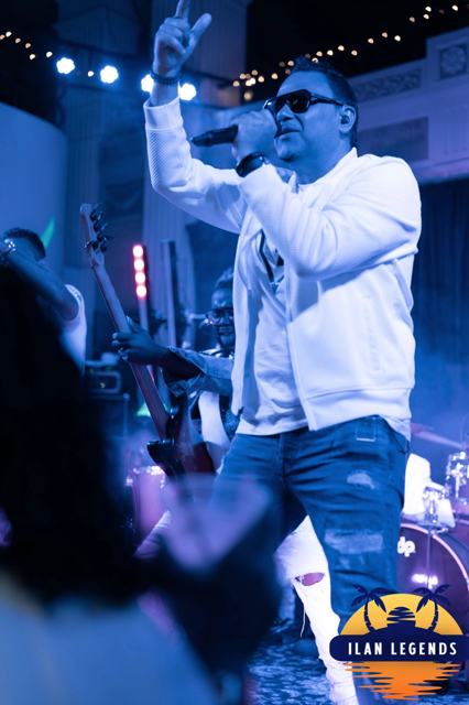 A singer performing with his hand raised
