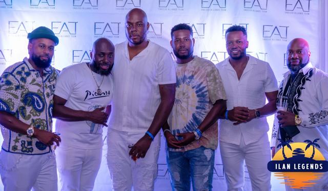 A group of men posing in front of the backdrop