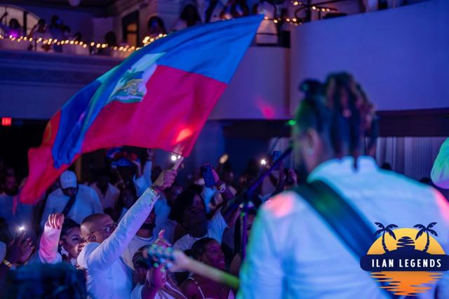 A Haitian flag waving over the crowd